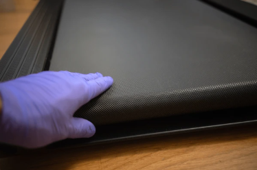 Image of man with purple rubber glove checking treadmill tread