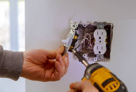 Image of hands of an home maintenance specialist installing a power switch