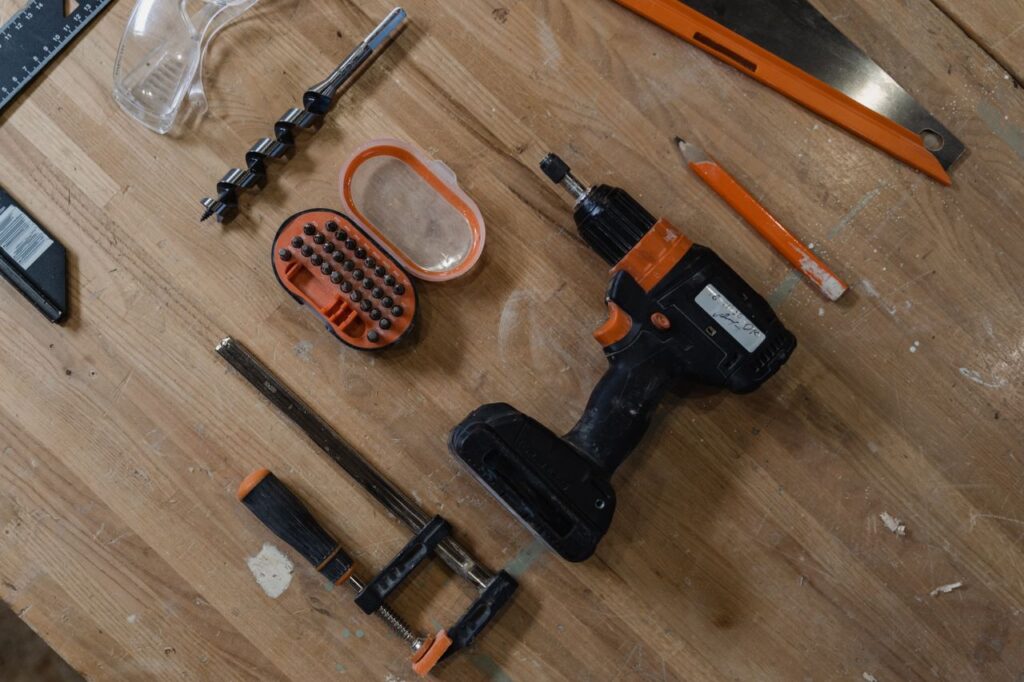 A selection of carpentry tools laid out on a wooden workbench, offering ample copy space.